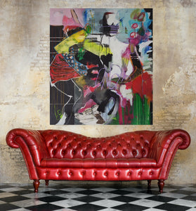 Red leather sofa in front of a colorful abstract painting on a textured wall.