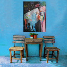 Load image into Gallery viewer, A colorful abstract painting of an buffalo hangs on a bright blue wall above a small rustic wooden table with two matching wooden chairs and two potted plants.
